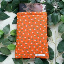 Load image into Gallery viewer, Birds eye view of Nothing Rhymes with Orange with a book peeking out the top of said book sleeve.