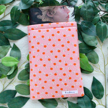 Load image into Gallery viewer, Pictured is a hardcover book that's coming out of the Peachy Keen book sleeve.