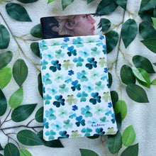 Load image into Gallery viewer, Pictured is a flat lay of Shamrock Fields, with a book peeking out of the sleeve.