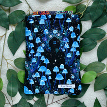 Load image into Gallery viewer, A book is pictured peeking out of Wild Witch. Flat lay style, taken in birds eye view.