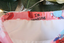 Load image into Gallery viewer, Go Away I'm Reading is being held open. Inside shows a white fabric inlay.