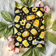 Load image into Gallery viewer, Various sizes and shaped jars containing honey, on a black background. There are puns on the labels of jars that read "Bee-licious," "Mind your bees + Qs," "Queen bee elixir," "Growing buzz," "Bee Loved," "Honey Bunny."