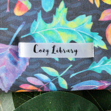 Load image into Gallery viewer, Close up of Cozy Library's shop tag on bottom right of product.