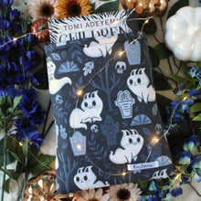 Load image into Gallery viewer, Ghost Kitties as a Medium-sized sleeve is shown how thick hardcover books fit into the book sleeve.