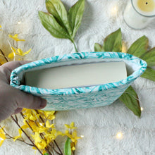 Load image into Gallery viewer, A hand is holding up a small sized Blue Tropical Palm book sleeve. Inside the sleeve is a paperback book.