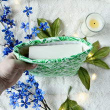 Load image into Gallery viewer, A hand is holding a Green Tropical Palm book sleeve, which has a small paperback novel inside it.