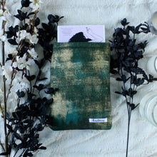 Load image into Gallery viewer, Green Gold Dust sits between black bunches of flowers. In the small-sized book sleeve is Emergency Contact by Mary H.K. Choi.