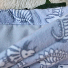 Load image into Gallery viewer, A close up shot of Dinos is showing that the fabric is soft and slightly fuzzy. Dinos is being held open, showing a light grey fabric inlay.