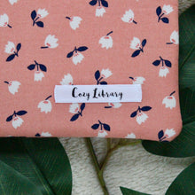 Load image into Gallery viewer, Close up picture of Eliza with a Cozy Library tag sewn into the bottom right of the product.
