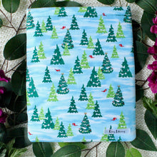 Load image into Gallery viewer, A Rudolph&#39;s Christmas book sleeve is pictured amongst Green leaves, and purple flowers.
