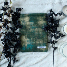 Load image into Gallery viewer, Green Gold Dust is between two bunches of black flowers with candles to the side.
